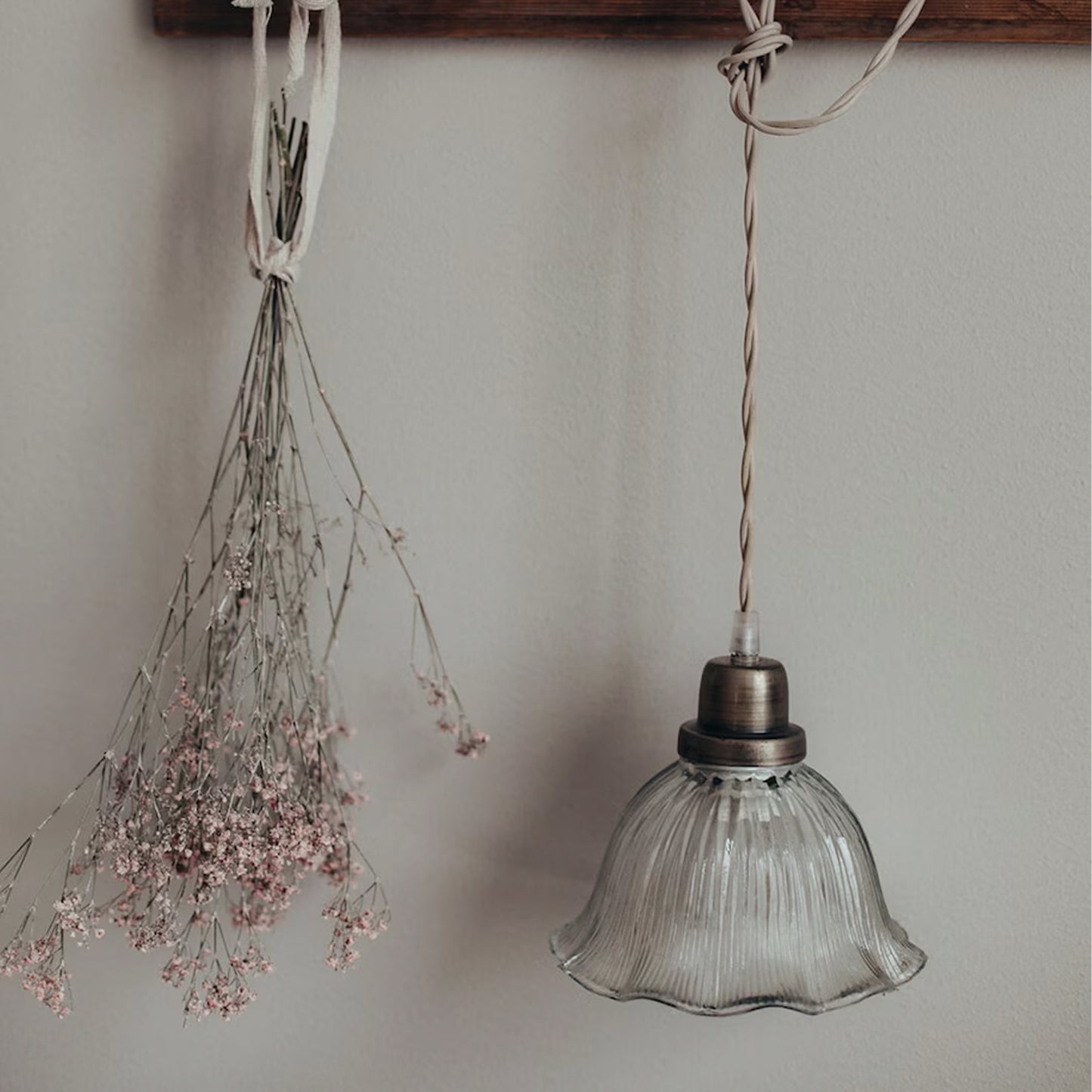 Rocio pendant lamp with wavy clear glass shade and antique brass fixture