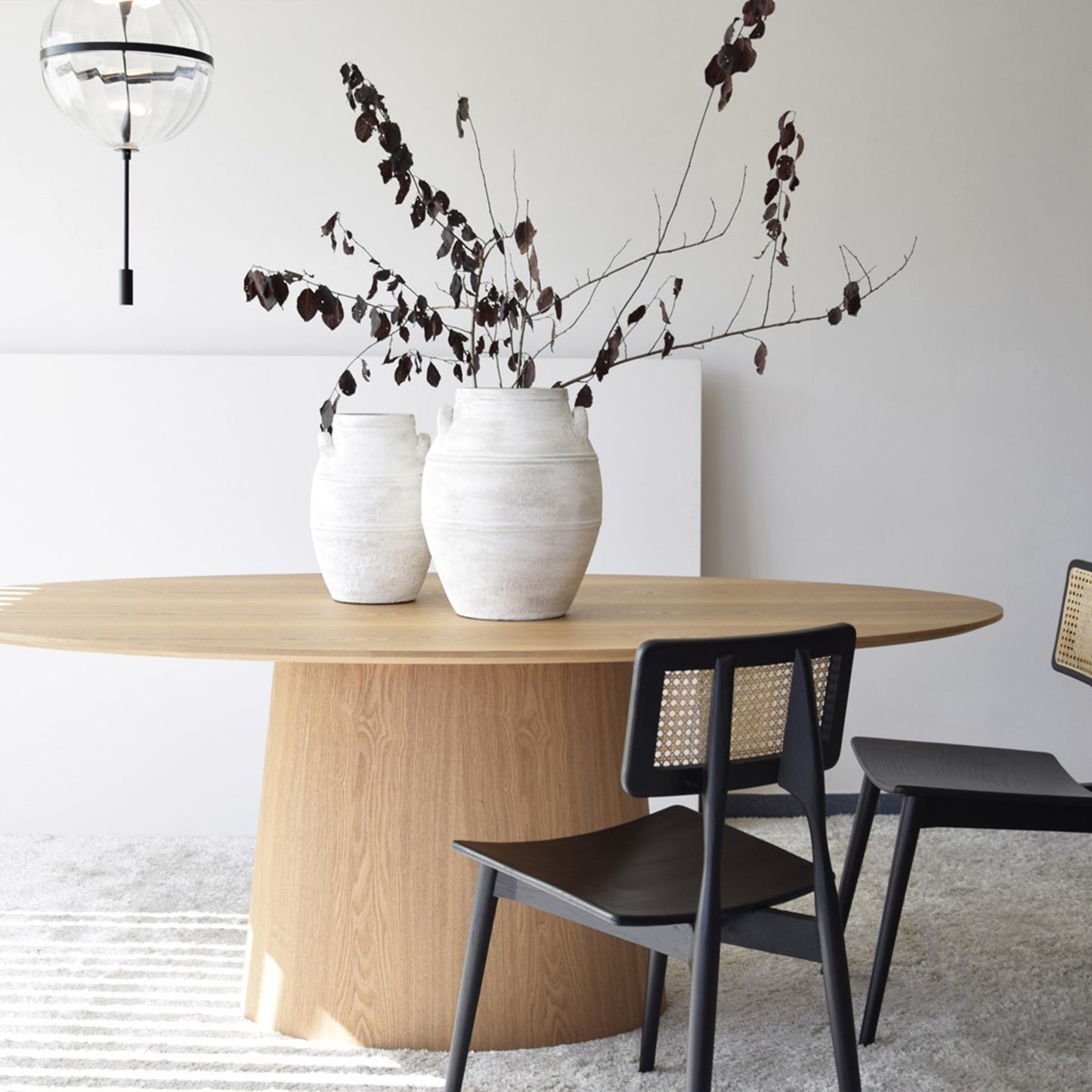 Maximo natural ash oval dining table with curved base and soft wood veneer finish