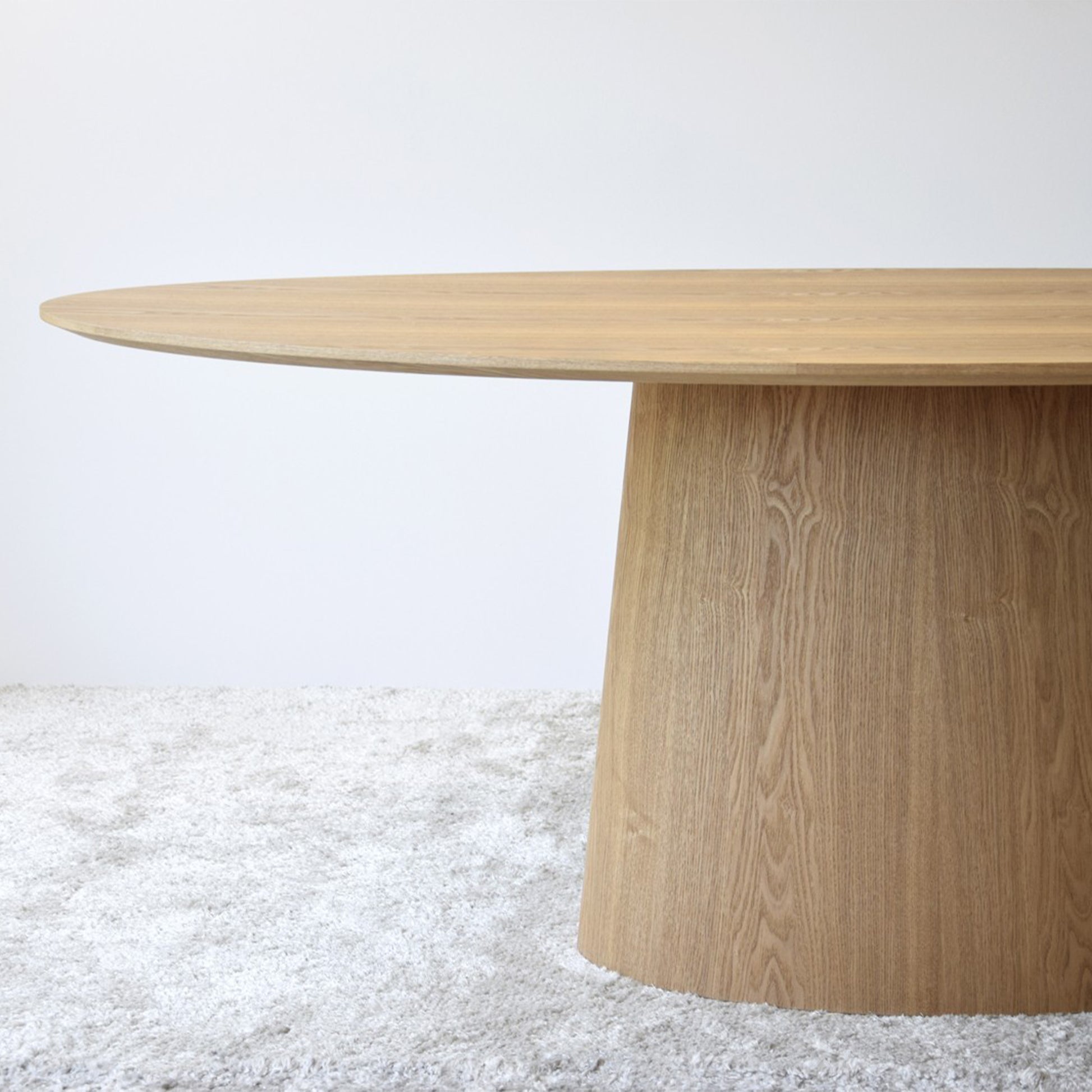 Maximo natural ash oval dining table with curved base and soft wood veneer finish