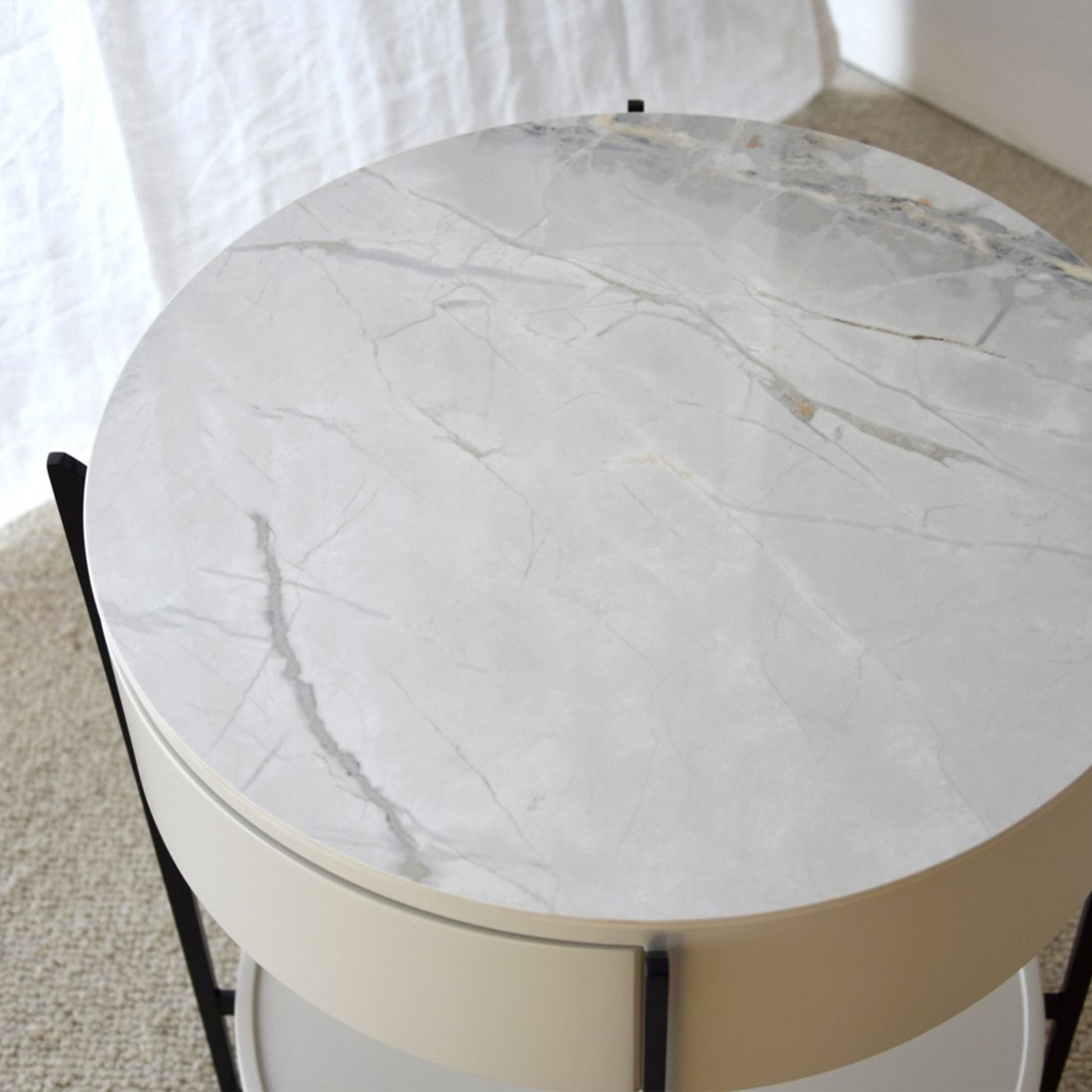 Juan White Ceramic Marble Side Table with round silhouette, drawer, and black metal legs