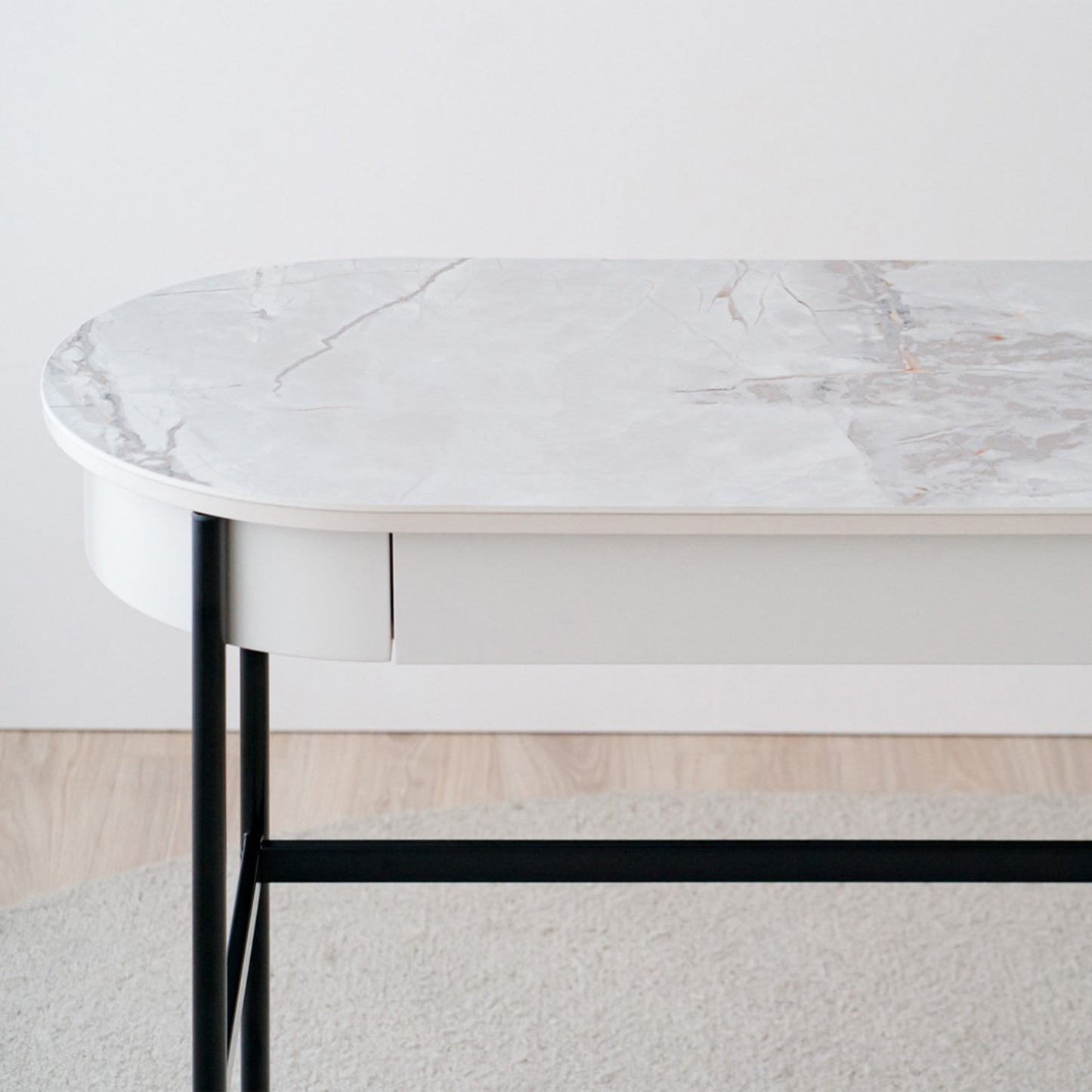 Iker White Ceramic Marble Desk with black legs, oval top, and lacquered drawer