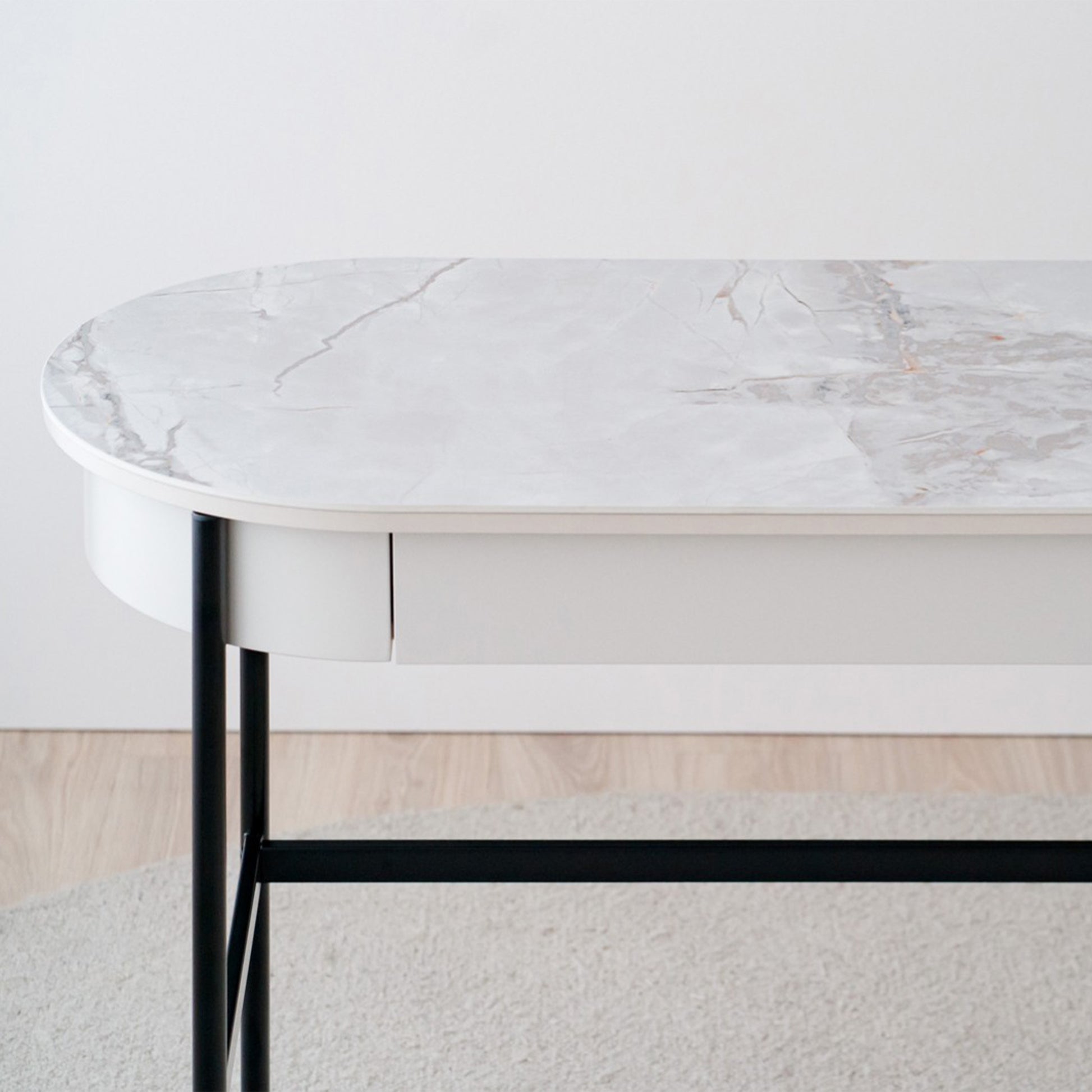 Iker White Ceramic Marble Desk with black legs, oval top, and lacquered drawer