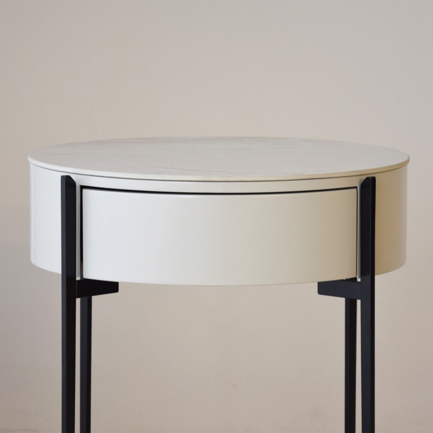 Juan White Ceramic Marble Side Table with round silhouette, drawer, and black metal legs
