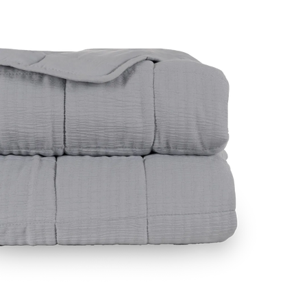 Martina beige and grey polyester quilts neatly folded in a bedroom setting